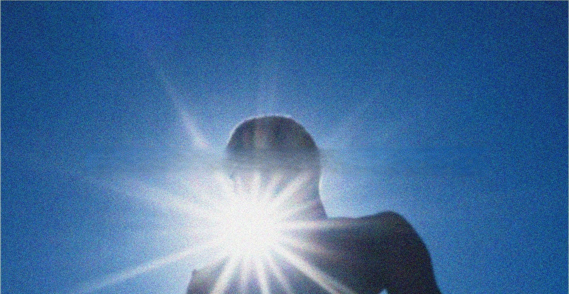 Silhueta contra o sol estourado no céu azul